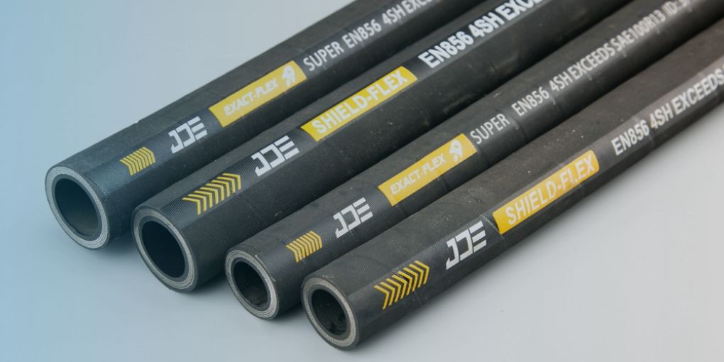 Three pieces of super custom EXACT_FLEX hoses on dark gray background.